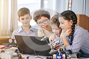 Happy children learn programming using laptops on extracurricular classes