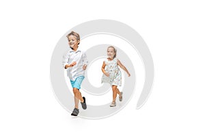 Happy children, little caucasian boy and girl jumping and running isolated on white background