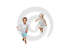 Happy children, little caucasian boy and girl jumping and running isolated on white background