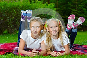 Happy children lying on green grass outdoors in