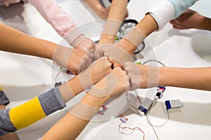 Happy children making fist bump at robotics school