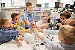 Happy children making high five at robotics school