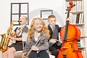 Happy children play musical instruments together