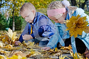 Happy children playing in autumn leaves