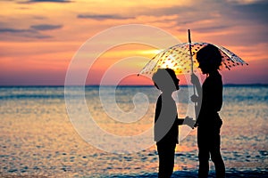 Happy children playing on the beach at the sunset time.