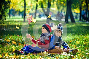 Happy children playing in beautiful autumn park on warm sunny fa