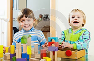 Happy children playing with blocks in home