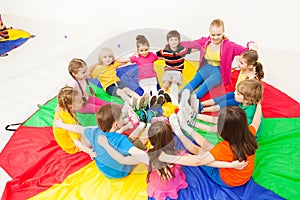 Happy children playing circle games with teacher