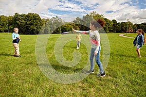 happy children playing with flying disc at park
