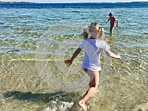 Happy children playing joyful on a beach at sea