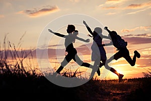 Happy children playing in the park at the sunset time