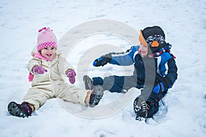 Happy children playing on snow in winter holiday.