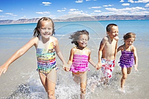 Happy Children playing and Splashing in the Ocean