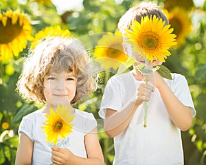 Happy children playing with sunflowers