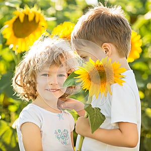 Happy children playing with sunflowers