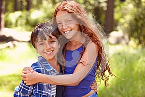 Happy children, portrait and hug with embrace for holiday, weekend or care together in nature. Little girl, boy and kids