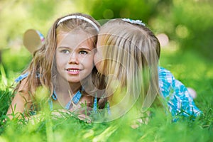 Happy children relaxing on green grass in summer park