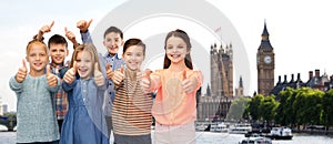 Happy children showing thumbs up over london