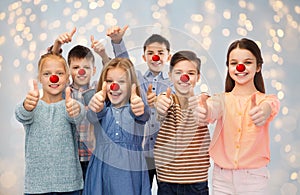 Happy children showing thumbs up at red nose day