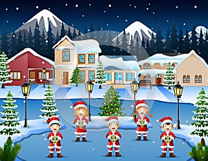 Happy children singing christmas carols in winter night landscape