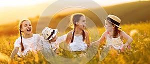 Happy children sit in the grass and laugh merrily in   field