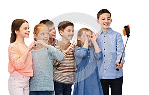 Happy children with smartphone and selfie stick