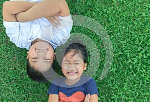 Happy children smile and lie down on grass