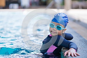 Happy children Smiling cute little girl in sunglasses in swimming pool