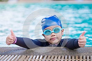 Happy children Smiling cute little girl in sunglasses in swimming pool