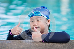 Happy children Smiling cute little girl in sunglasses in swimming pool