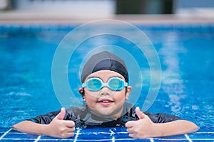 Happy children Smiling cute little girl in sunglasses in swimming pool