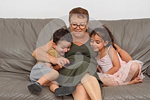 Happy children smiling at phone with grandmother.