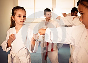 Happy children sparring in pairs in karate class