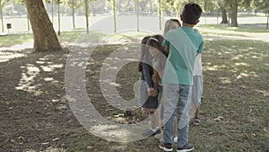 Happy children standing, holding hands and playing game