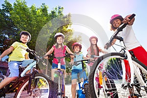 Happy children with their bicycles in summer park photo