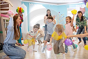 Happy children and their parents entertain and have fun with color balloon on birthday party