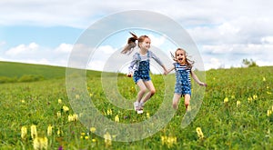 Happy children twins sisters jumping and laughing in summer