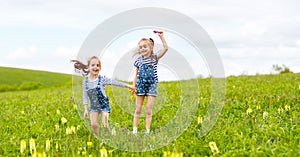 Happy children twins sisters jumping and laughing in summer