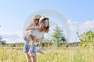 Happy children two girls sisters laughing and having fun in meadow