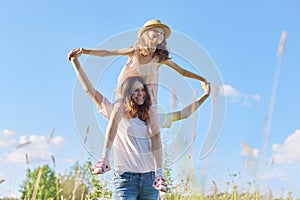 Happy children two girls sisters laughing and having fun in meadow