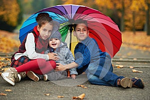 Happy children under rainbow umbrella