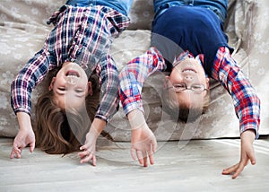 Happy children upside down on the sofa