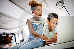 Kids, technology concept. Happy children using laptop to learn, play, fun.