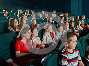 Happy children watching movie at the cinema.