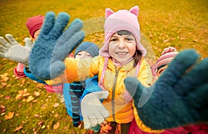 Happy children waving hands in autumn park