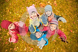 Happy children waving hands in autumn park