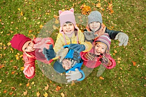 Happy children waving hands in autumn park