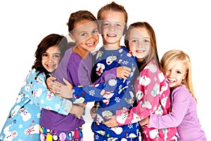 Happy children in winter pajamas hugging each other