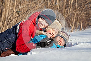 Happy children in winterwear playing in snowdrift