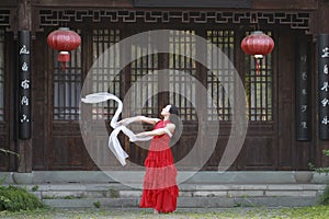 Happy Chinese beauty is dancing in red dress